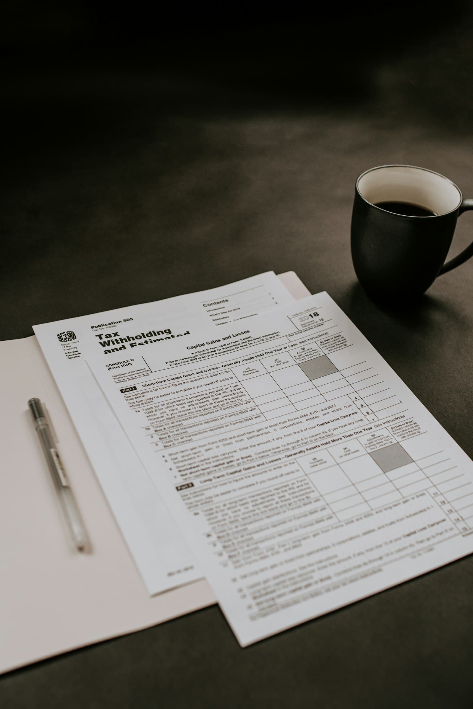 Stack of business invoices on an office desk with financial documents
